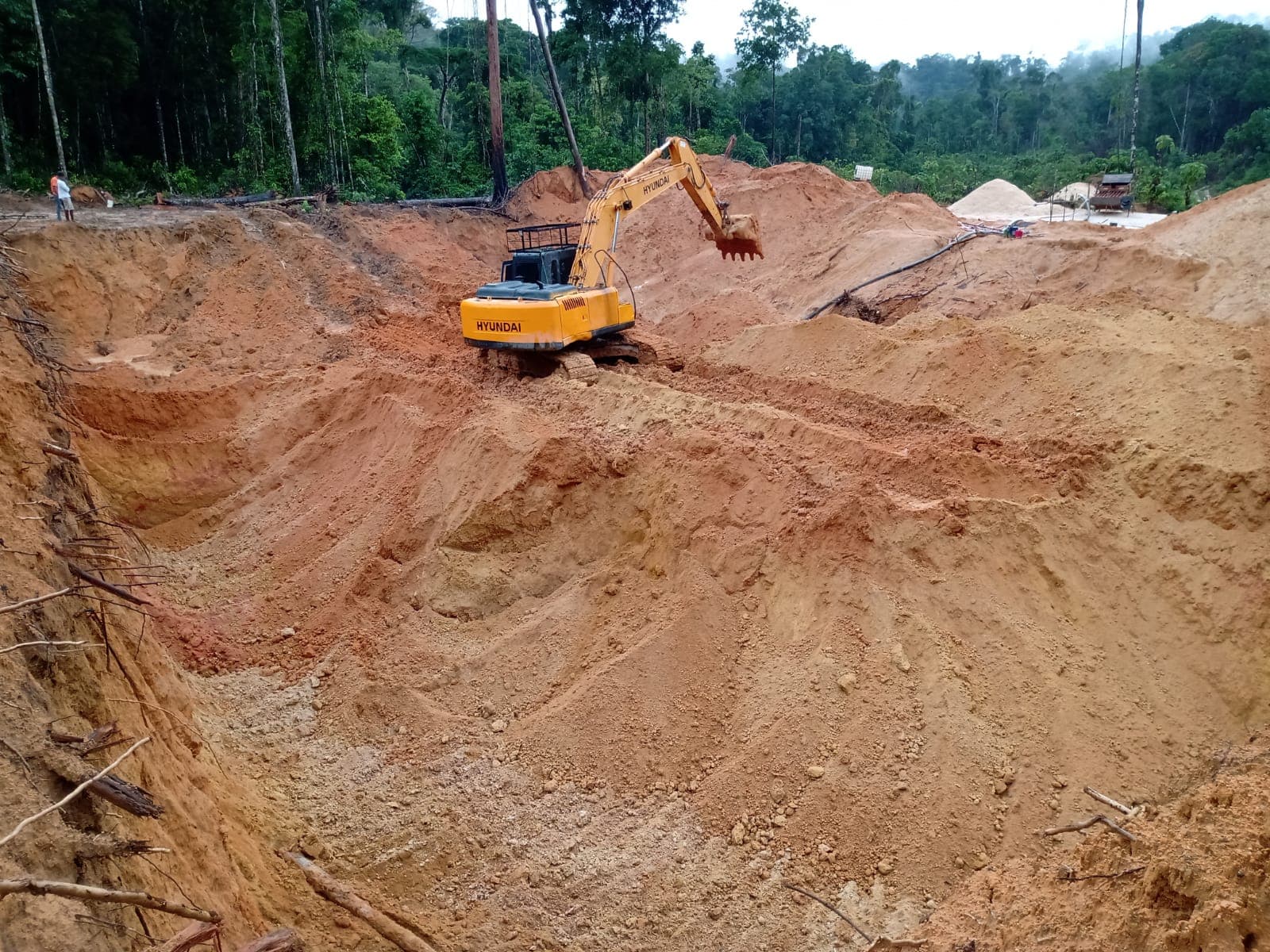 Escavadeira trabalhando em uma área de garimpo